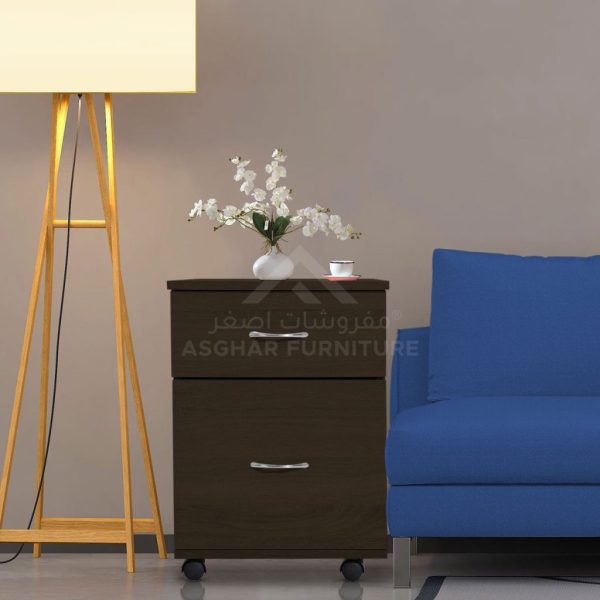 A dark brown two-drawer rolling file cabinet with silver handles, placed next to a blue sofa and a floor lamp.