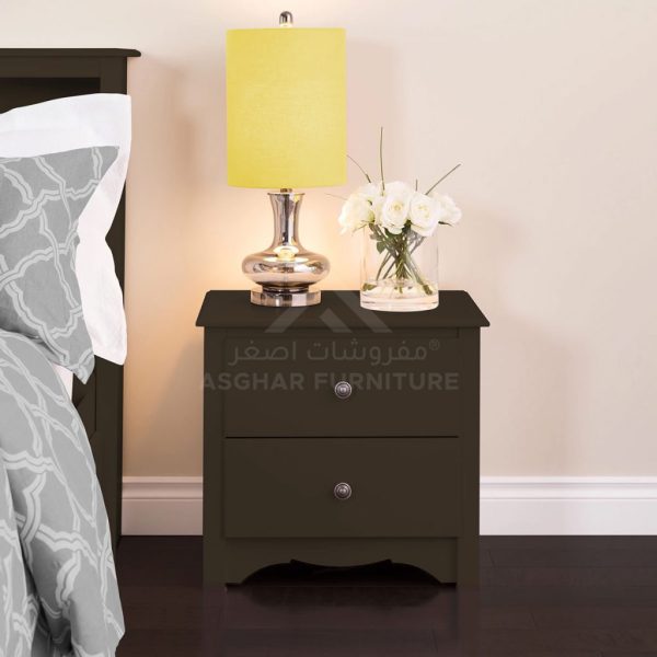 A dark brown two-drawer nightstand with round silver knobs, holding a lamp and a vase of white flowers.