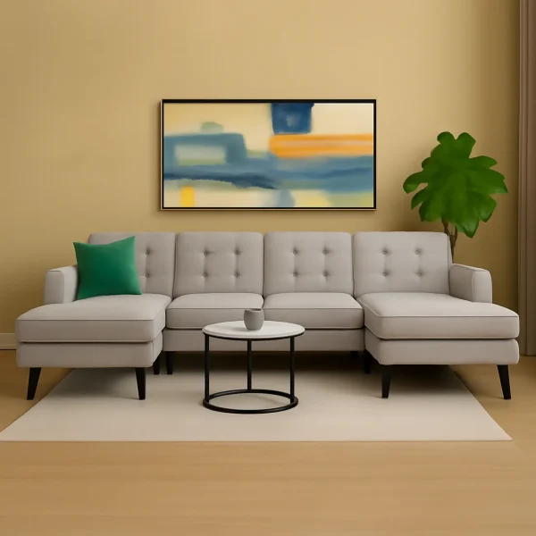 A large light gray U-shaped sectional sofa with tufted cushions, a round coffee table, and an abstract painting above it.