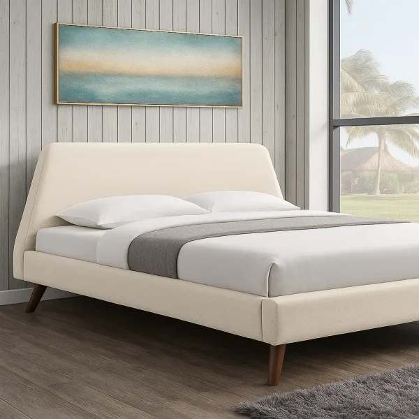 A cream-colored upholstered bed with an angled headboard and wooden legs, in a bright, modern room.