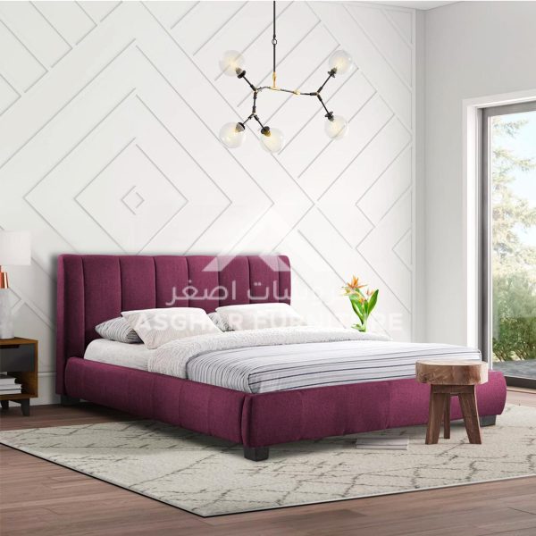 A purple channel-tufted upholstered bed with white and striped bedding, and a light-colored rug.