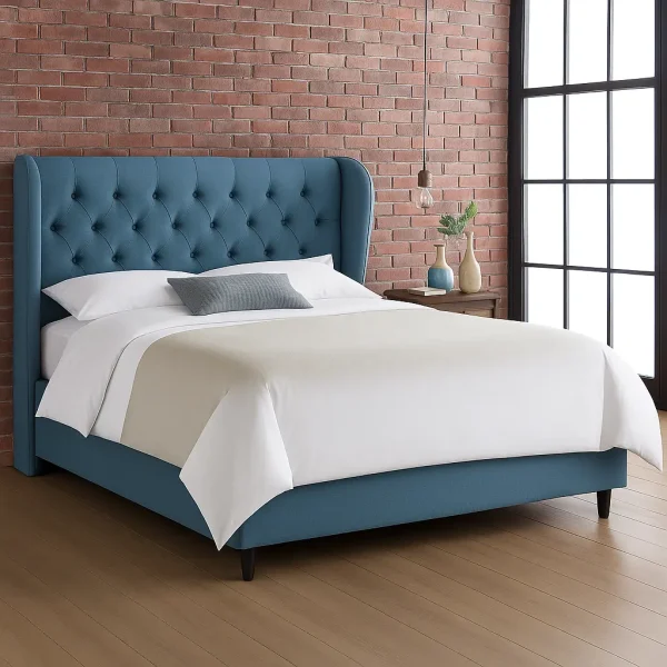 A teal tufted upholstered bed with a wingback headboard, and a brick wall in the background.