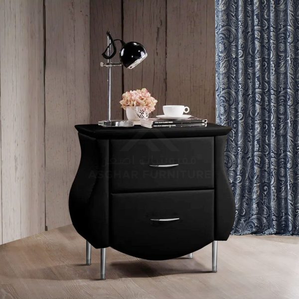 A modern black nightstand with two drawers, curved sides, silver legs, and a black desk lamp.