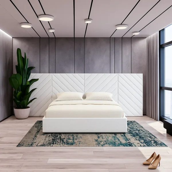 A sleek white platform bed with a large, chevron-patterned headboard, set on a distressed blue and brown rug.