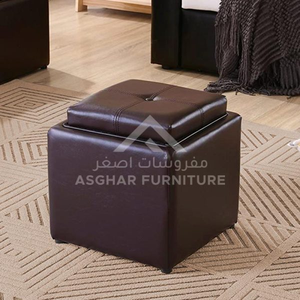A small square dark brown leather ottoman with a tufted lid that doubles as a tray.