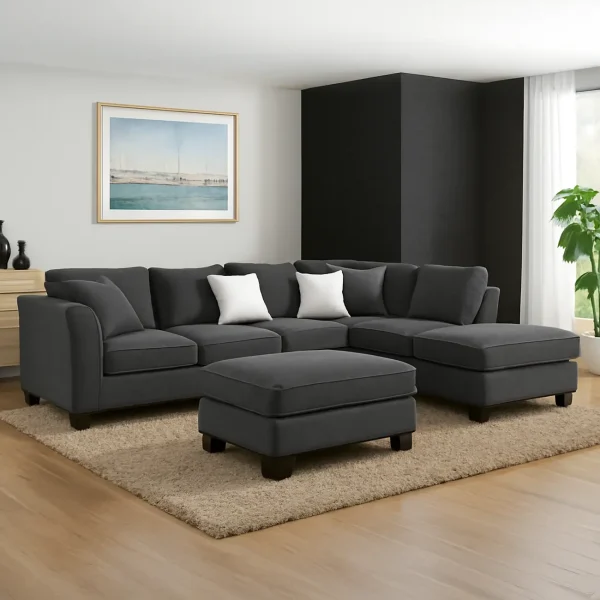A dark gray sectional sofa with a chaise lounge and a matching ottoman. The sofa has plump cushions and is accented with two white throw pillows.