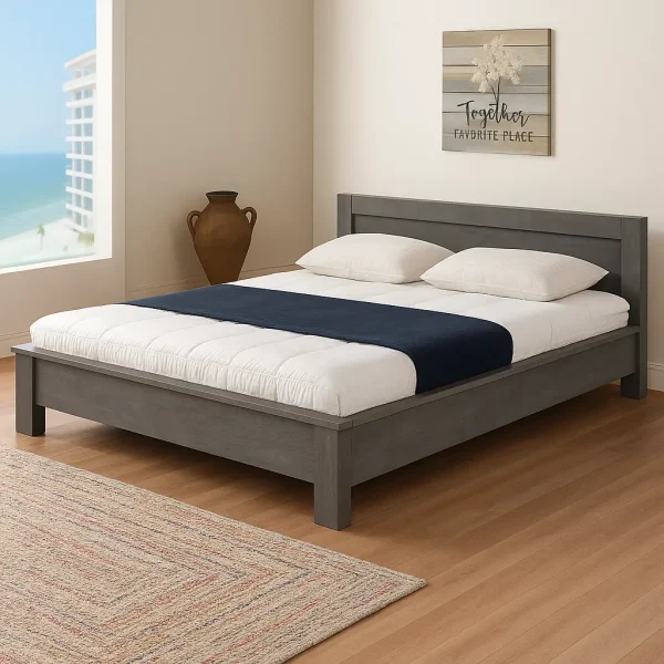 A grey wooden bed with white and navy bedding, a large vase, and a framed wall art piece.
