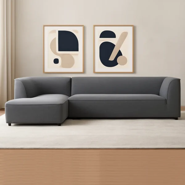 A contemporary dark gray L-shaped sectional sofa with a chaise lounge. The sofa has a streamlined design with rounded edges.