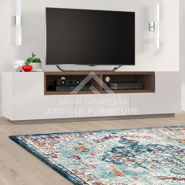 A large white and wood TV unit with two cabinets and open shelves, with a television and a rug.