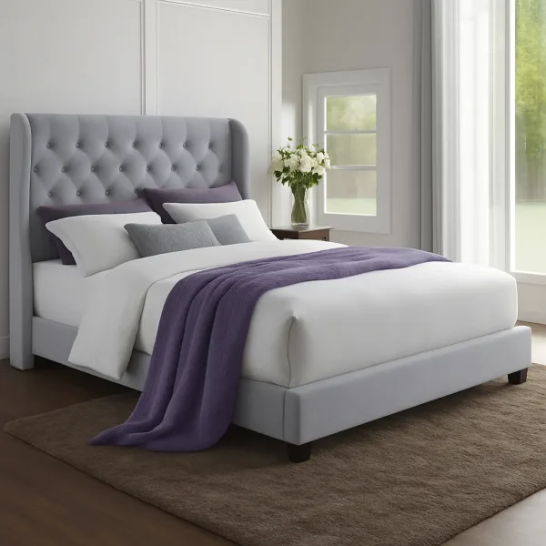 A gray tufted wingback upholstered bed with a purple throw blanket.