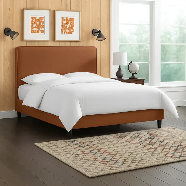 A simple brown upholstered bed with a plain headboard, and two orange abstract art prints on the wall.