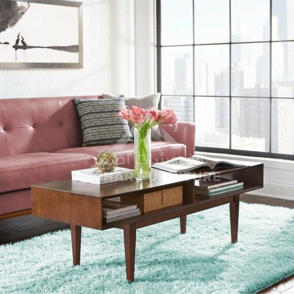 A mid-century modern style coffee table in dark wood with a drawer and open shelves, on splayed legs.