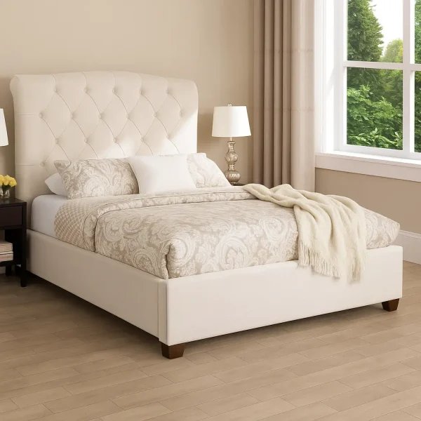 A luxurious cream tufted upholstered bed with a high headboard and a low footboard.