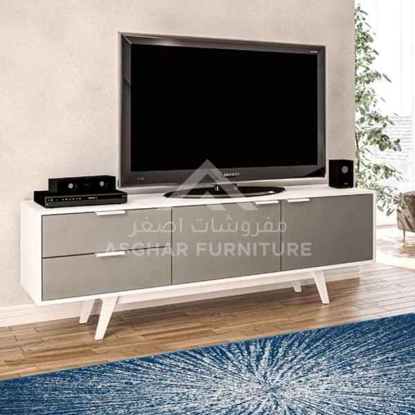 A wide contemporary white TV stand with gray drawers and a TV on top.