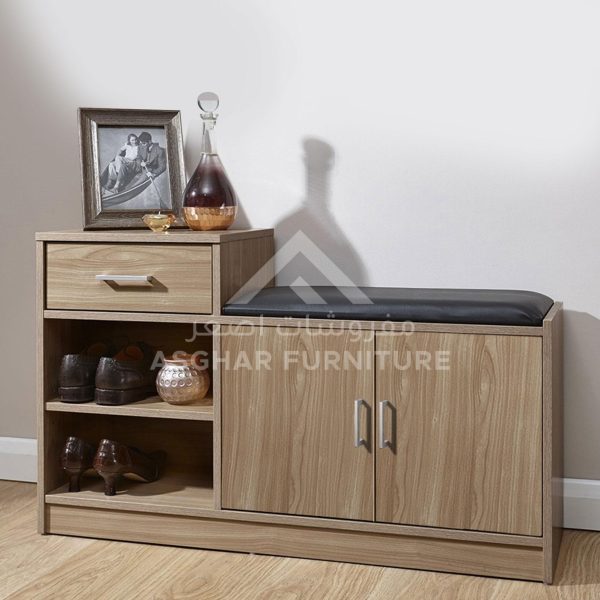 A multi-purpose light wooden shoe cabinet with a black padded seat, a drawer, and open shelves.