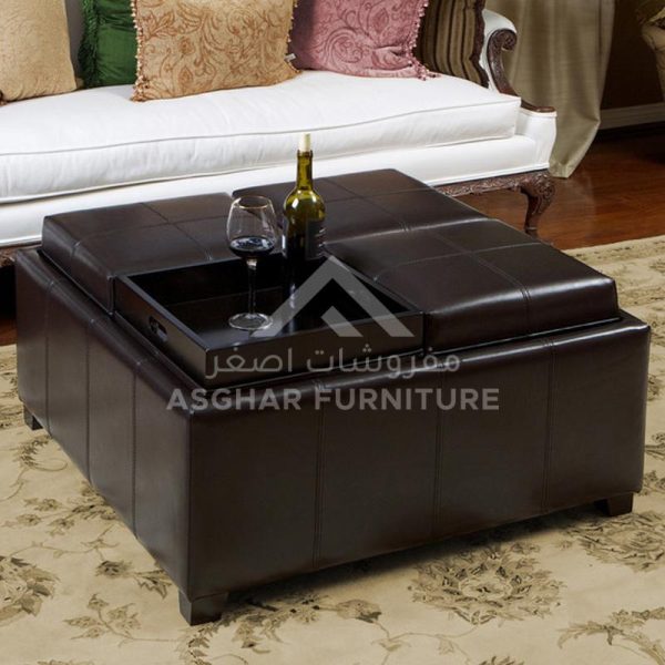 A square, brown leather ottoman with a tufted top that lifts to reveal two inner storage compartments and a wooden tray.