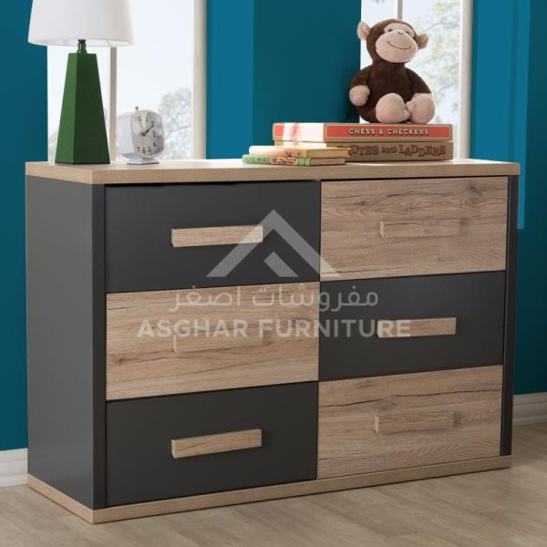 A two-toned dresser with six drawers in dark grey and light wood, topped with a lamp and a monkey plush.