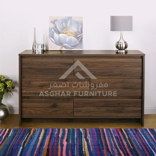 A contemporary wooden dresser with six drawers, featuring a large flower painting and a lamp.