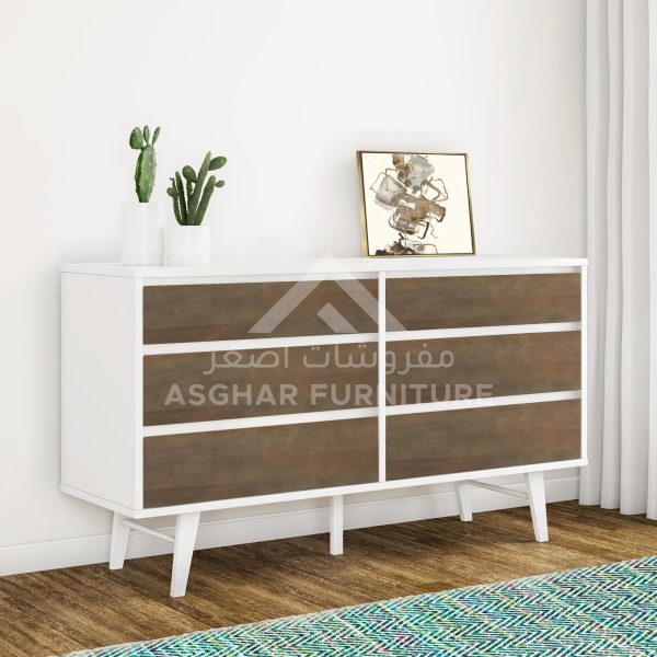 A white and wood two-tone six-drawer dresser with splayed legs, topped with cacti and abstract art.