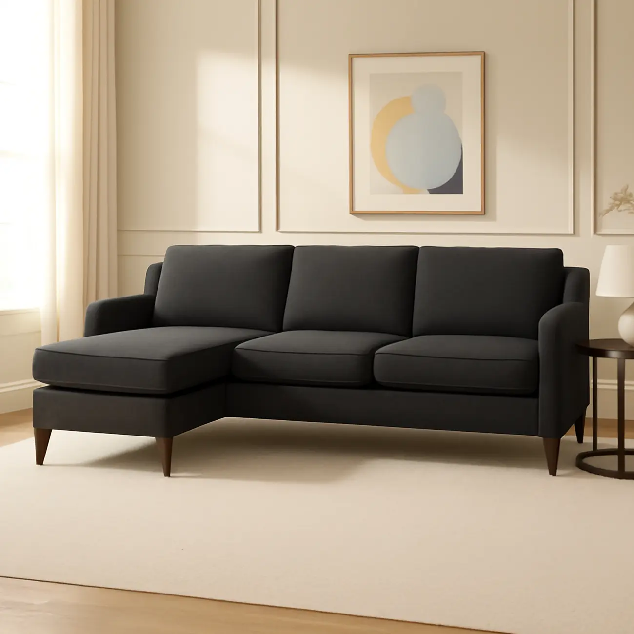 A dark gray L-shaped sectional sofa with a chaise lounge. The sofa has a simple, modern design with cushioned backrests and straight, tapered wooden legs.