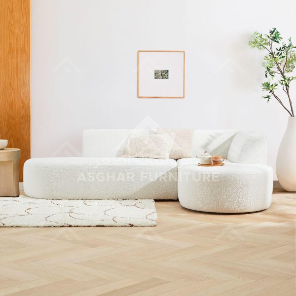 A contemporary living room with a white, boucle fabric modular sofa and a matching ottoman.