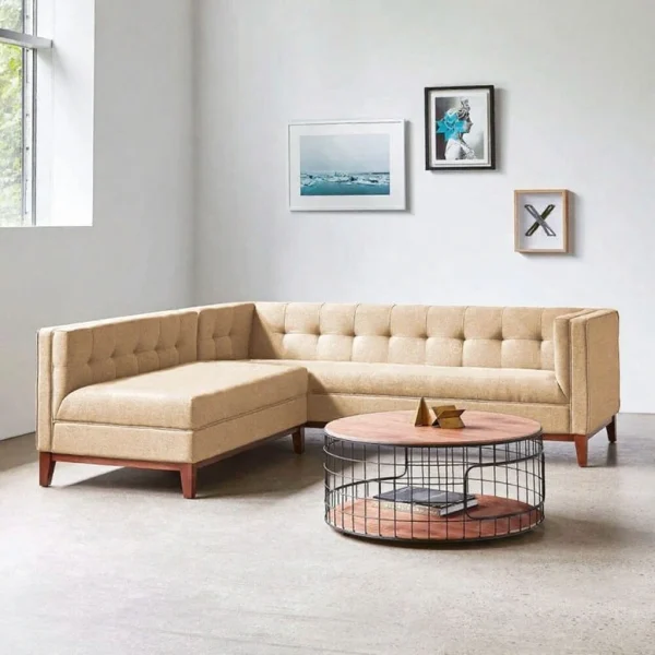 A tan fabric L-shaped sectional with button tufting and a chaise, paired with a wire-base coffee table.