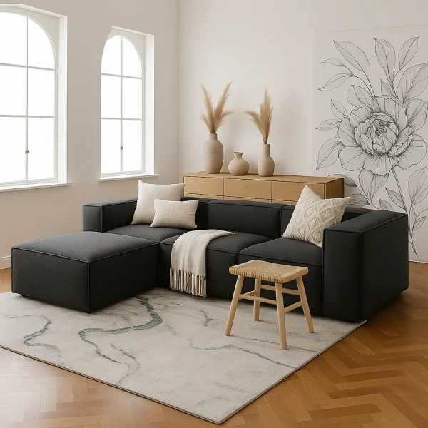 A charcoal gray modular sectional sofa with a chaise lounge. It's decorated with various throw pillows and a blanket.