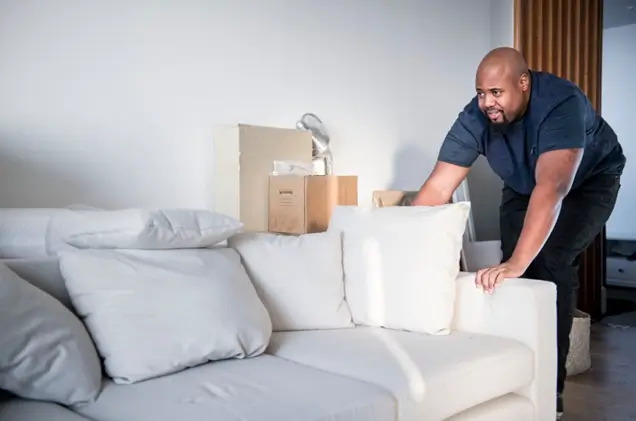 man moving a sofa