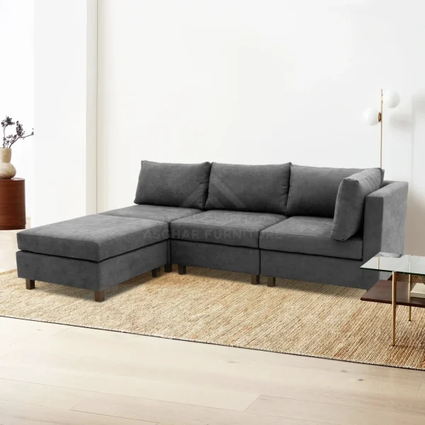 A large gray sectional sofa with a plush appearance, pillows, and a large jute rug underneath.