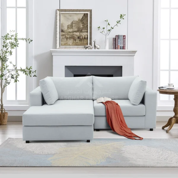 Modern light grey sectional sofa with a chaise lounge, styled with an orange throw blanket in a contemporary living room.