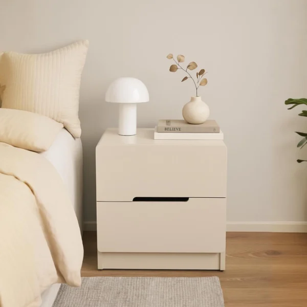 Modern light beige nightstand with two drawers, styled in a minimalist bedroom setting