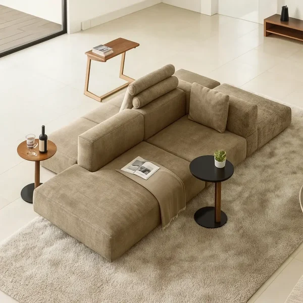 A contemporary modular beige sectional sofa with various side tables and a plush rug.