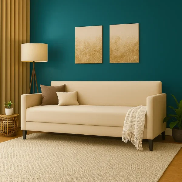 A modern cream sofa with accent pillows and a throw, on a patterned rug against a teal wall.