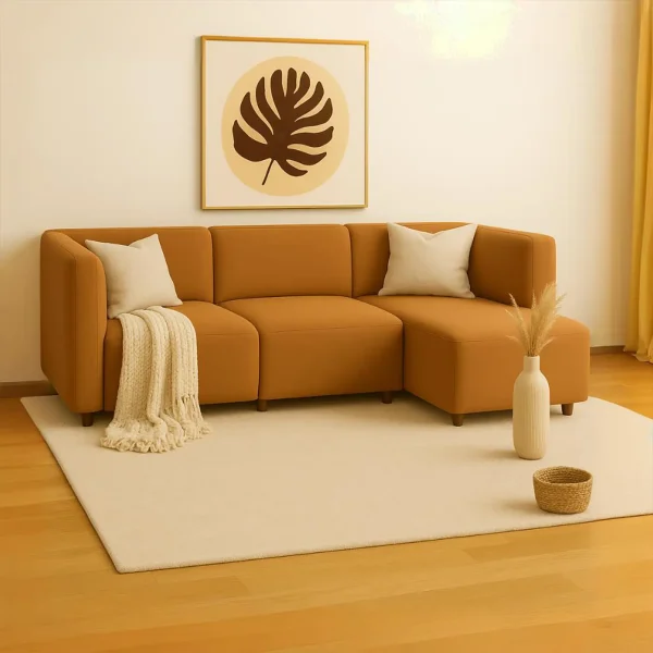 A warm-toned modular sectional sofa with cream pillows and a throw, on a light rug with decor.