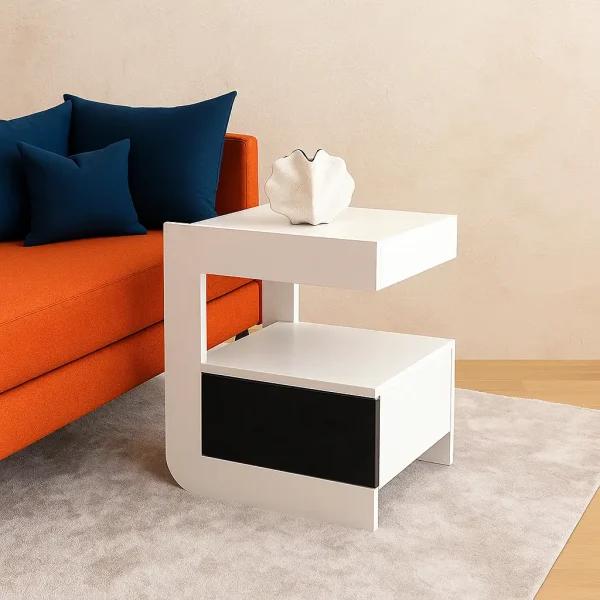 A contemporary white and black side table with an open shelf, a drawer, and a decorative vase on top.