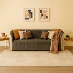 A stylish gray and cream sofa with a bronze throw blanket and pillows in a modern living room setting.