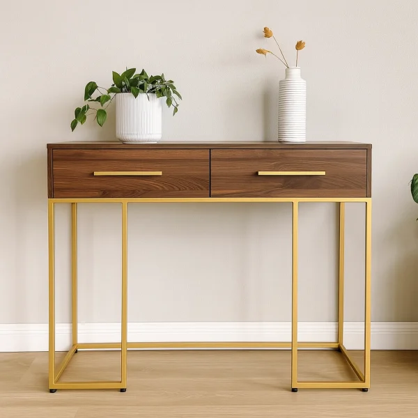 A mid-century modern console table with a dark wood top, two drawers, and a gold metal frame.