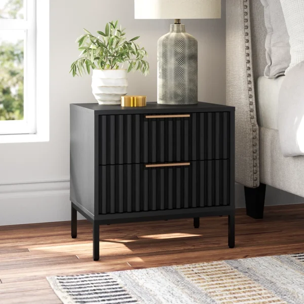 A stylish black nightstand with two drawers, a plant, and a textured lamp on a wooden floor.