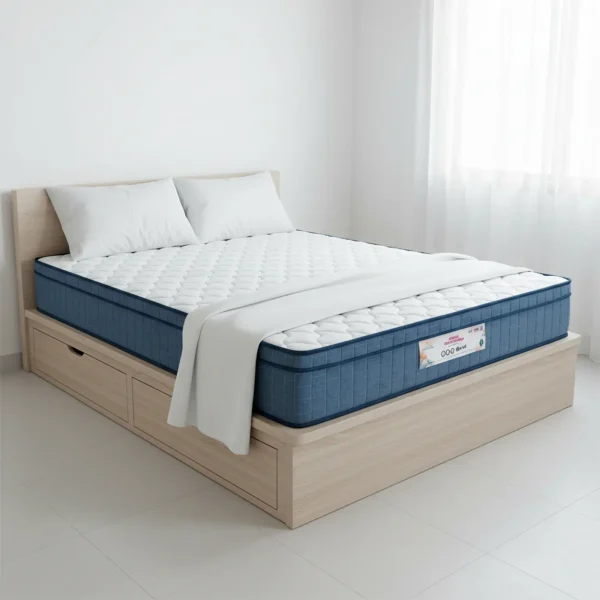 A quilted mattress with a blue border sits on a light wood platform bed with storage drawers.
