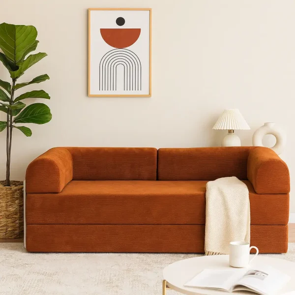 A minimalist rust-colored modular sofa with a unique rounded shape and a small side table in a clean, modern room.