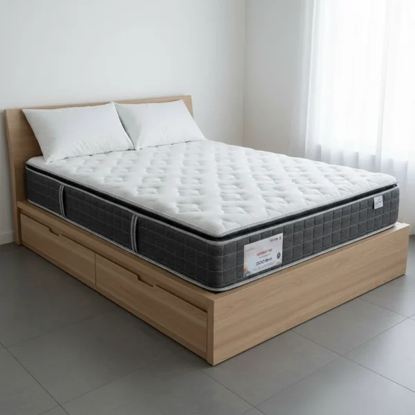 A thick pillow-top mattress with a gray quilted side panel sits on a light wood storage bed frame.