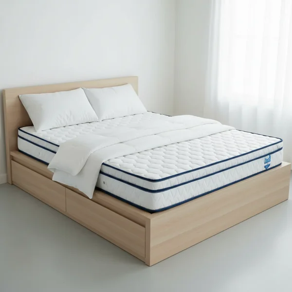 A quilted white mattress with blue piping rests on a light wood platform bed with two drawers.
