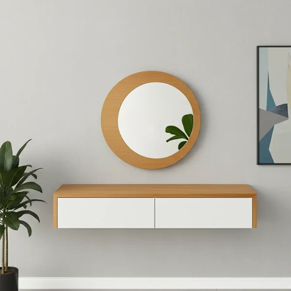 A floating wall console with a light wood top and two white drawers is mounted below a round wood-framed mirror.