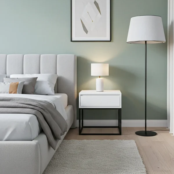 A white channel-tufted upholstered bed is next to a white nightstand with a black metal base.