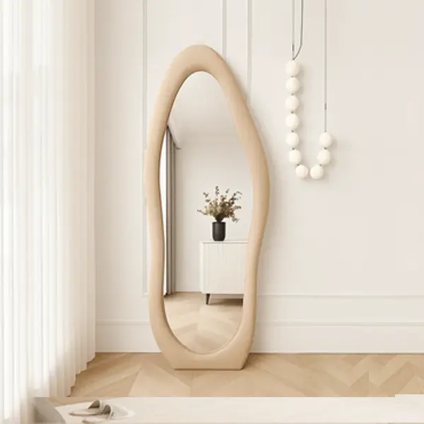 A modern, full-length mirror with a wavy, irregular shape and a beige frame.