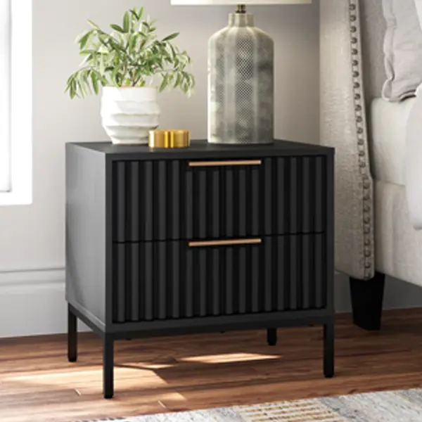 A stylish, black two-drawer nightstand with a fluted texture and gold hardware.