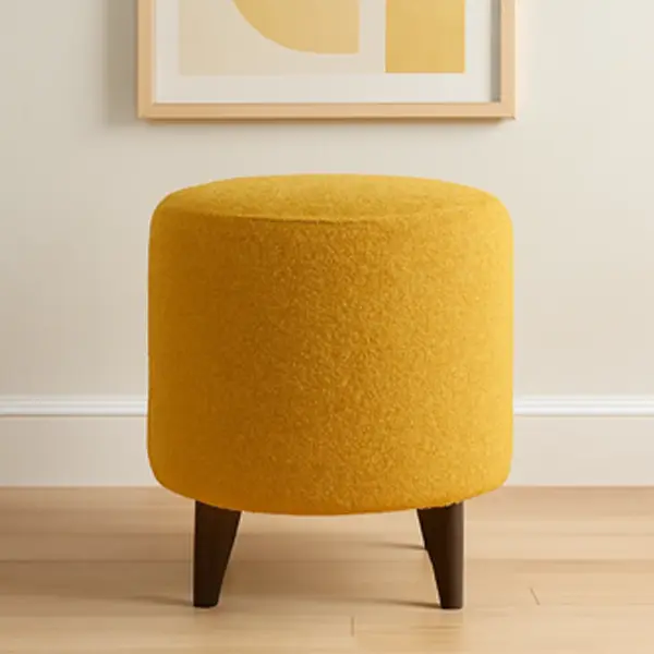A vibrant, round yellow ottoman with textured boucle fabric and dark wood legs.